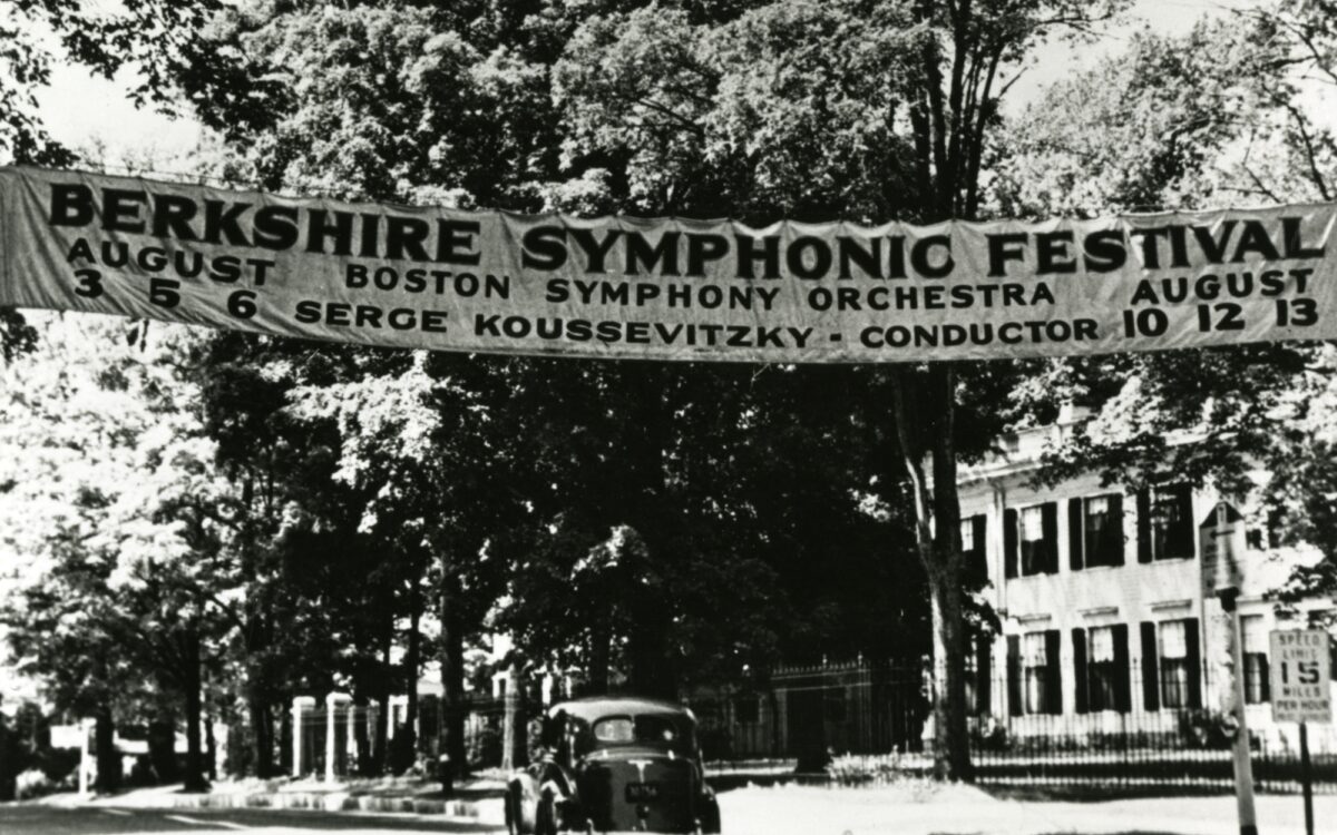 A banner announcing the 1939 Berkshire Symphonic Festival stretches across a tree-lined street with a single automobile on it.