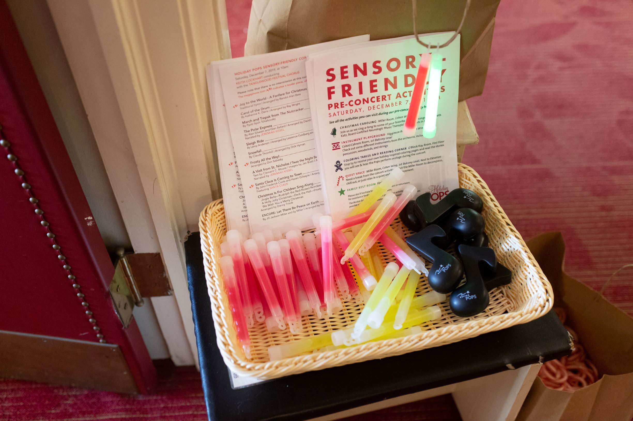 Close-up of basket holding music note shaped fidgets, glow sticks, and paper programs.