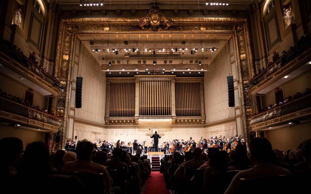 We see Thomas Wilkins conducting the BSO from the perspective of the audience.