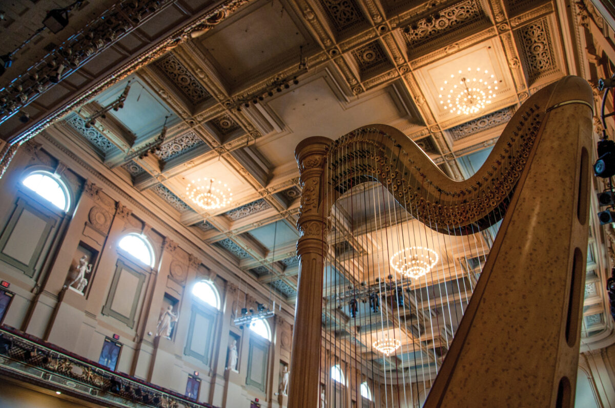 The top half of a harp with a view of Symphony Hall behind it