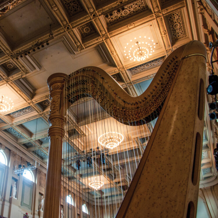 close up of a harp on stage at Symphony Hall in Boston with sunshine pouring in through the windows