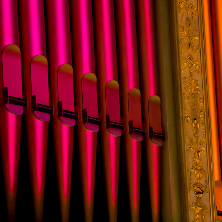 A close up of red and orange organ pipes