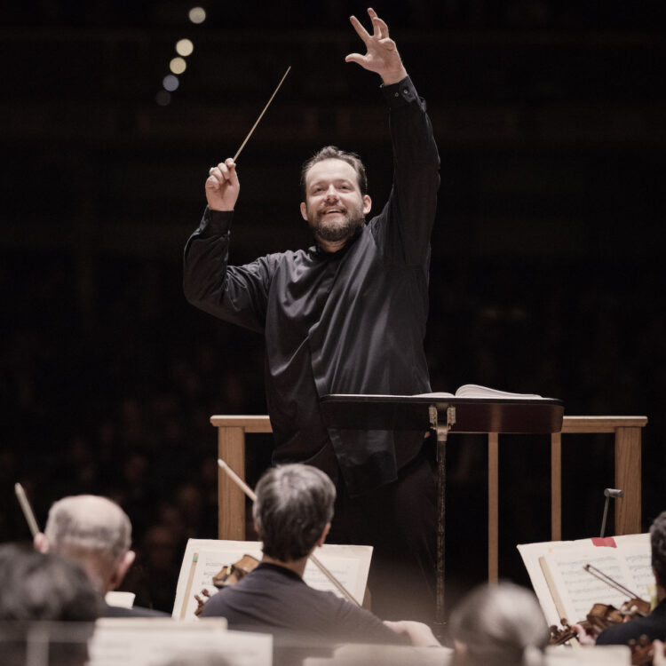 Andris Nelsons smiling while conducting