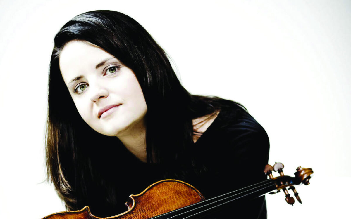 Baiba Skride sitting with her violin in her hands