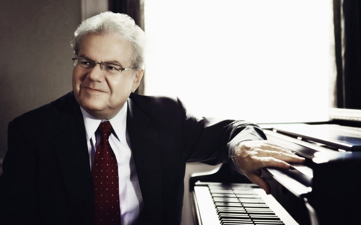 Emanuel Ax sitting a piano and smiling