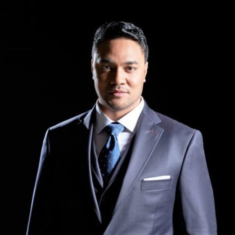 Headshot of Amitai Pati in a grey suit with a black background