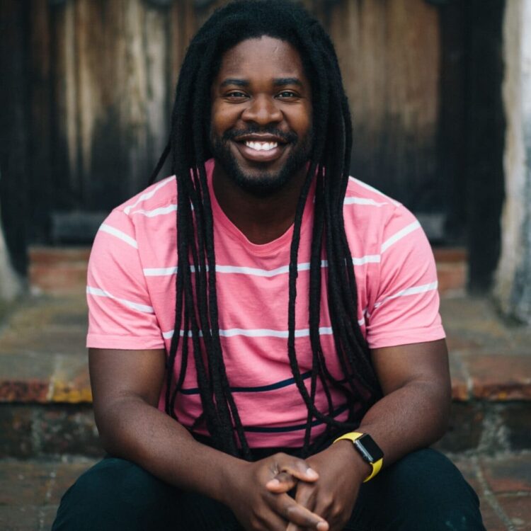 Dashon Burton sitting on brick steps, smiling
