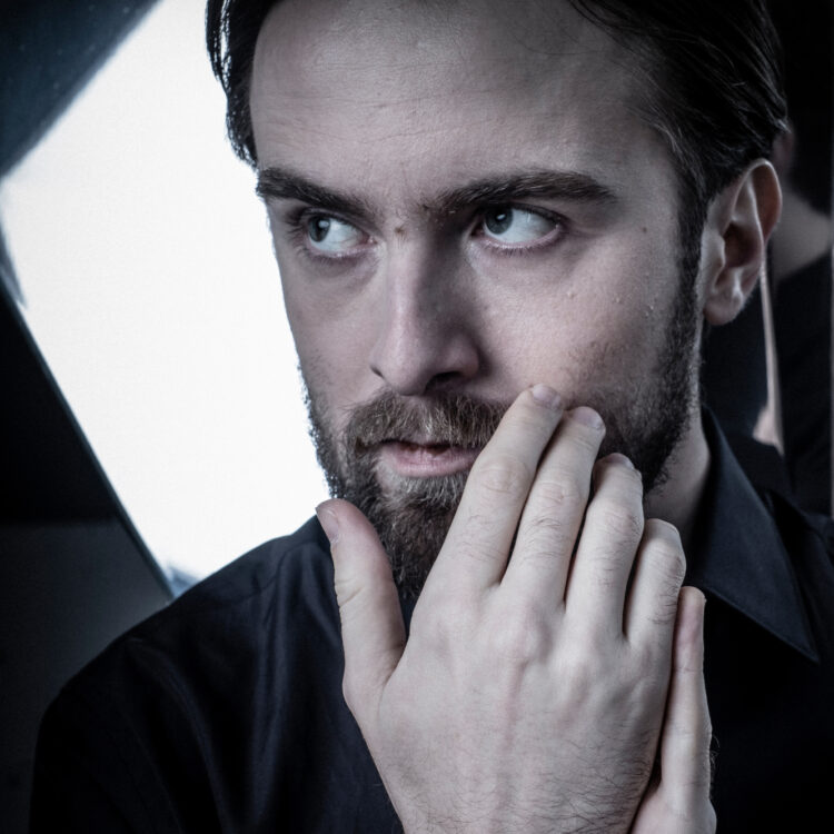 Daniil Trifonov standing in front of a mirror with his hands in front of his face