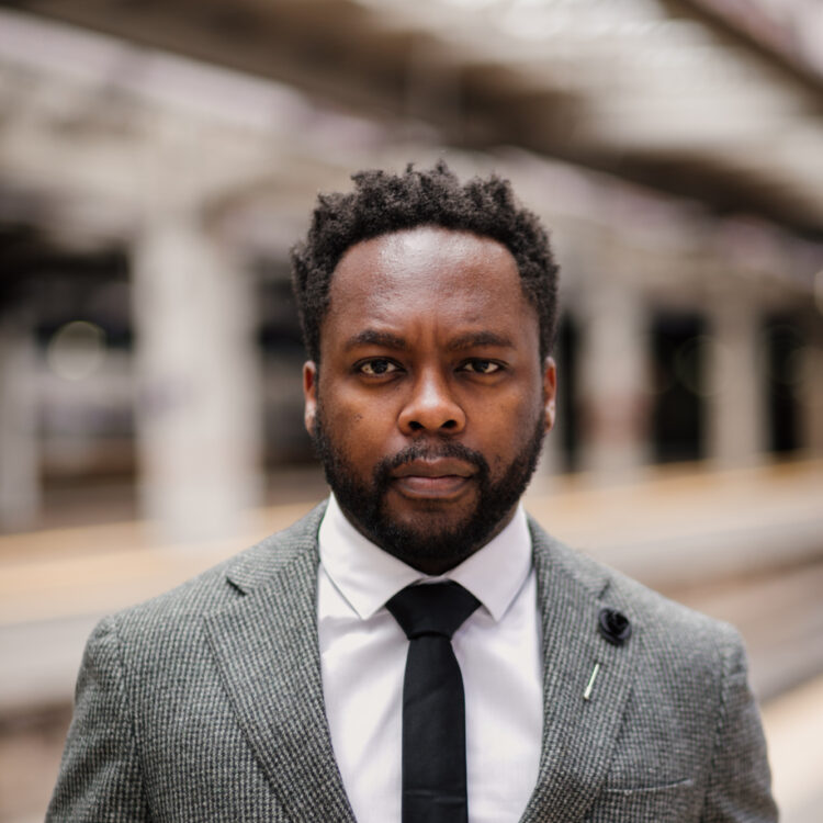 Headshot of Will Liverman in a grey suit