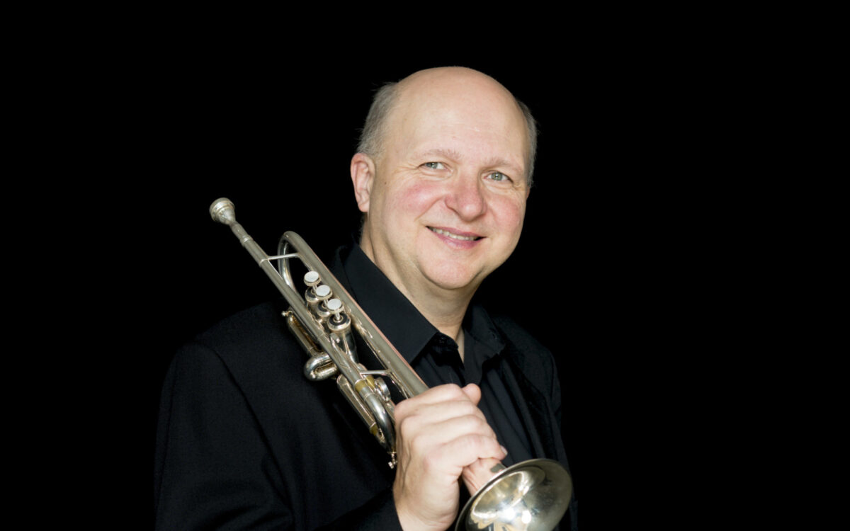 Thomas Rolfs headshot with trumpet