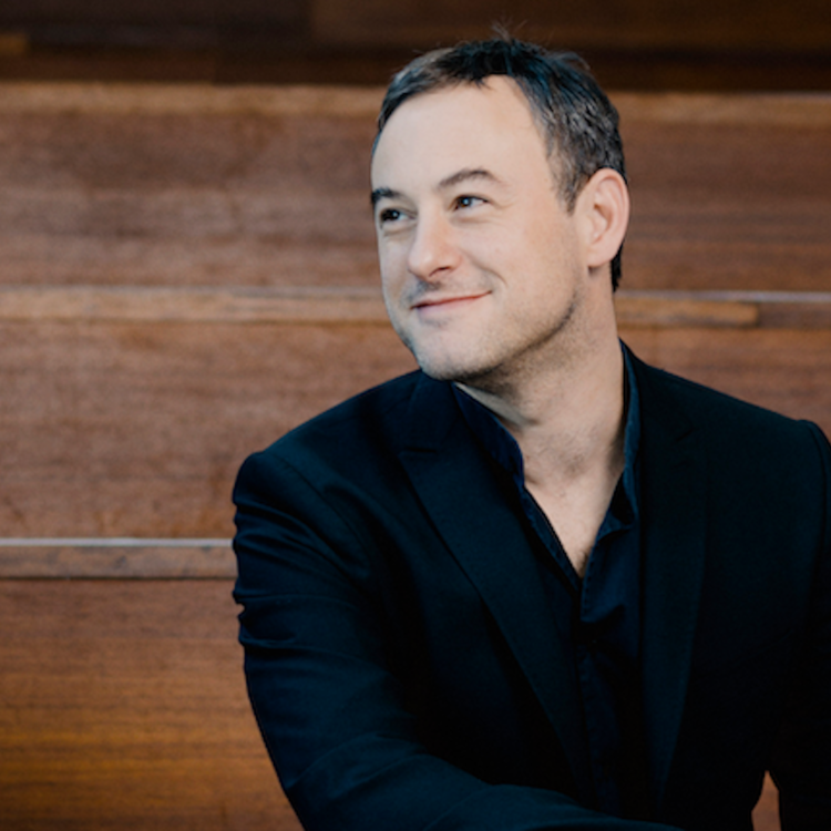 conductor Jonahan Cohen sitting and smiling
