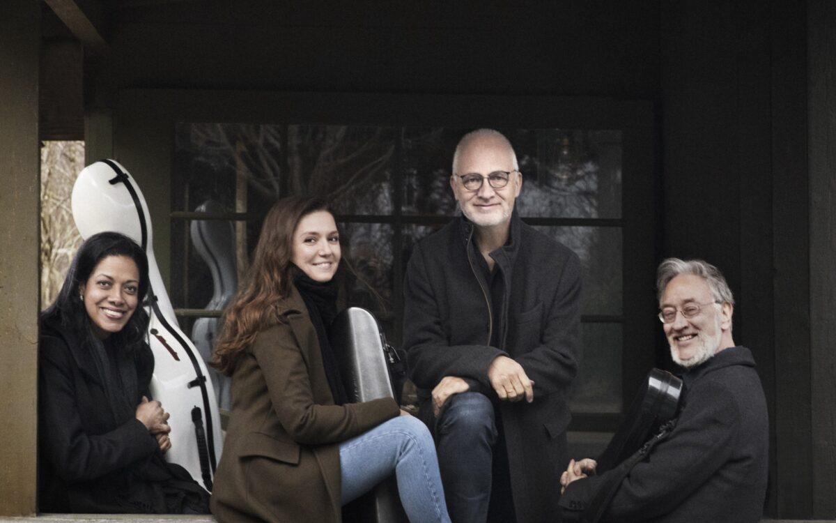 The four members of the Juilliard String Quartet posing for the camera with their instrument cases.