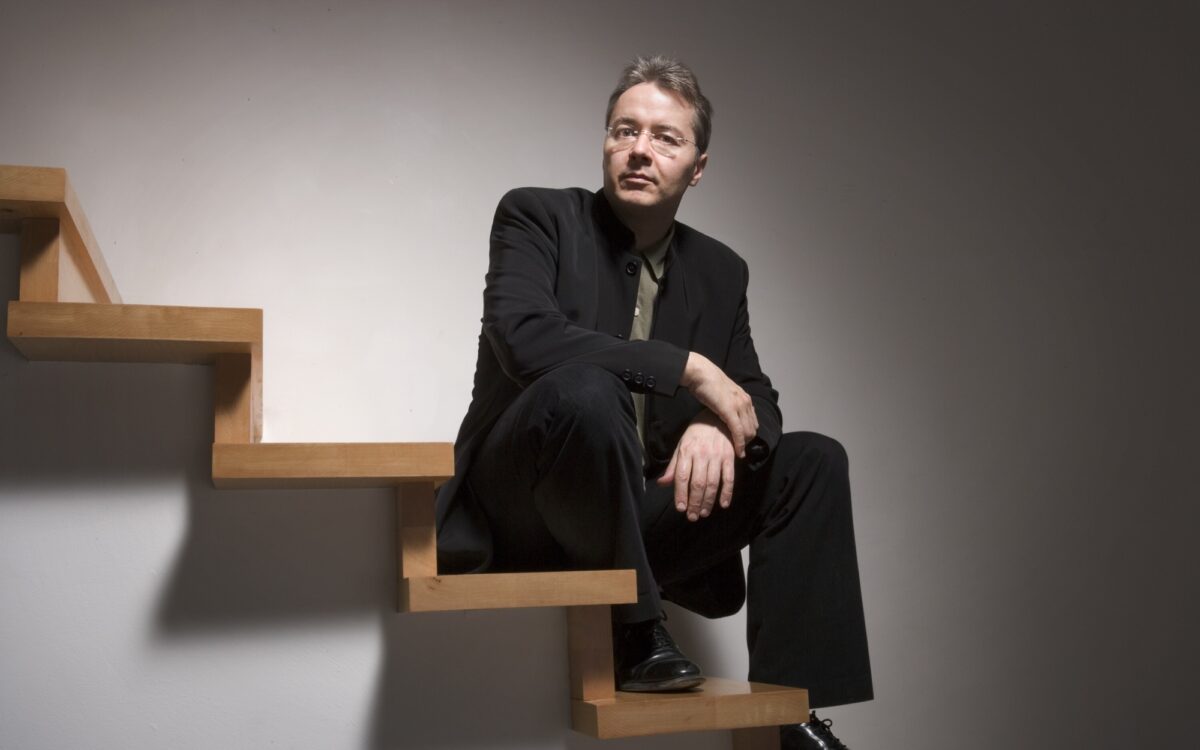 Stefan Asbury sitting on wooden stairs
