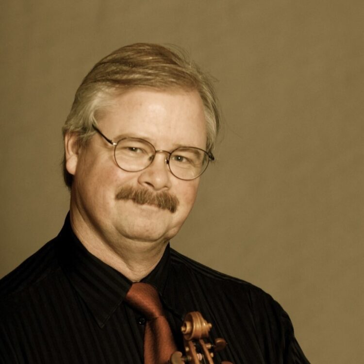 Andrew Jennings headshot holding his violin and bow