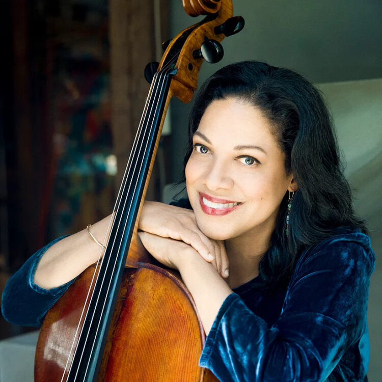 Astrid Schween headshot resting her hands and chin on her cello