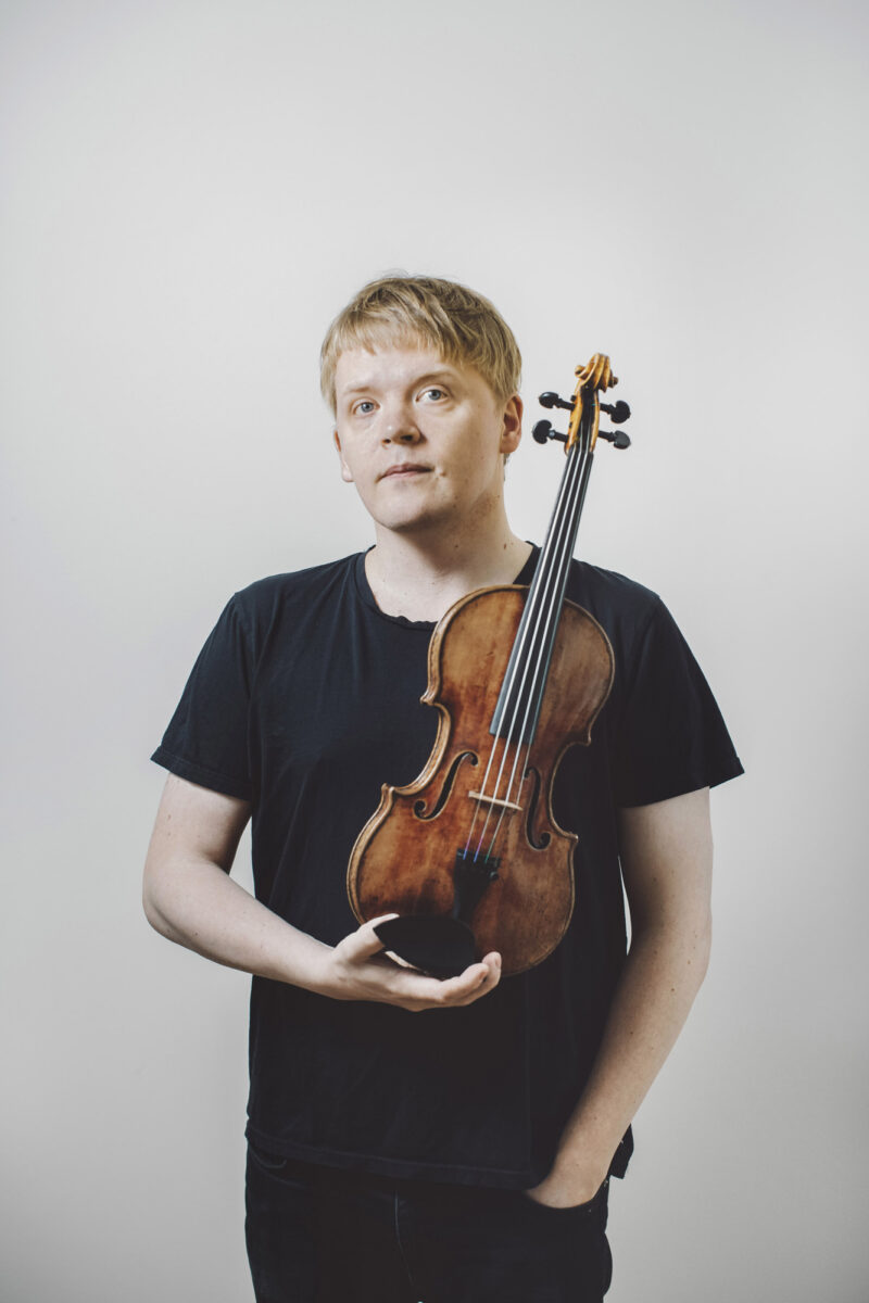 Pekka Kuusisto holding a violin