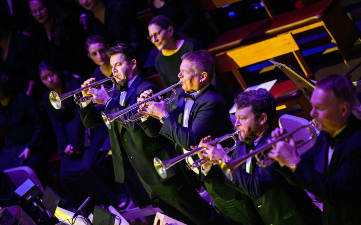 The trumpet section standing to perform a fanfare