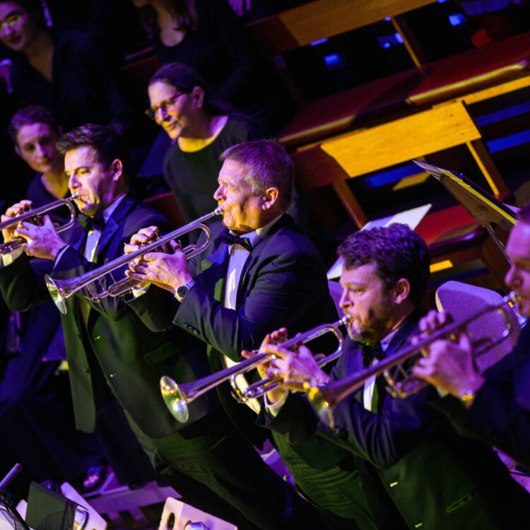 The trumpet section standing to perform a fanfare